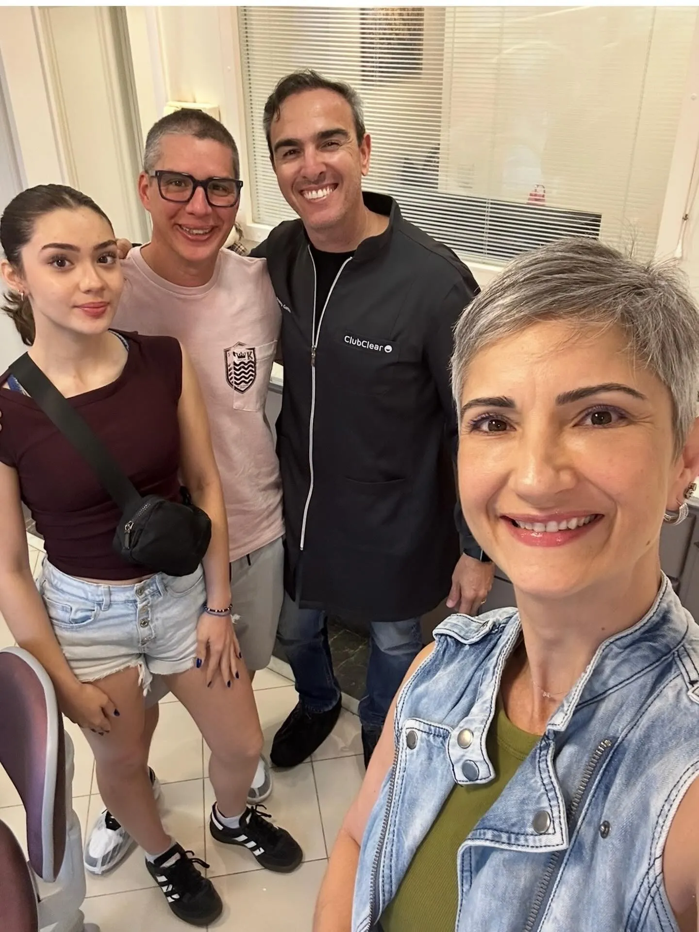 Selfie de uma família de pacientes com o Dr. Rodrigo Garbim, todos sorrindo