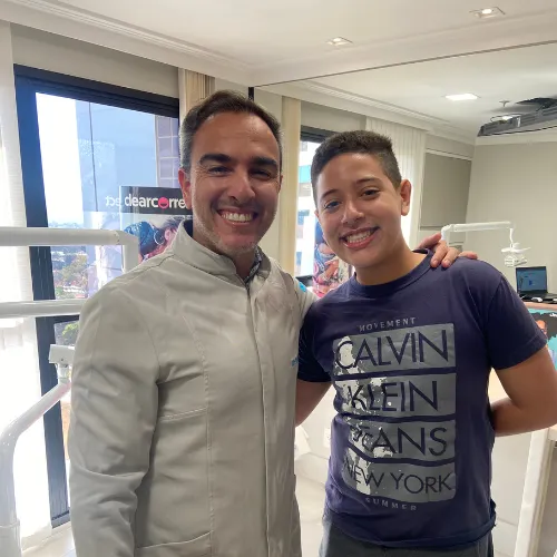 Dr. Rodrigo Garbim com um paciente jovem de camiseta azul-marinho